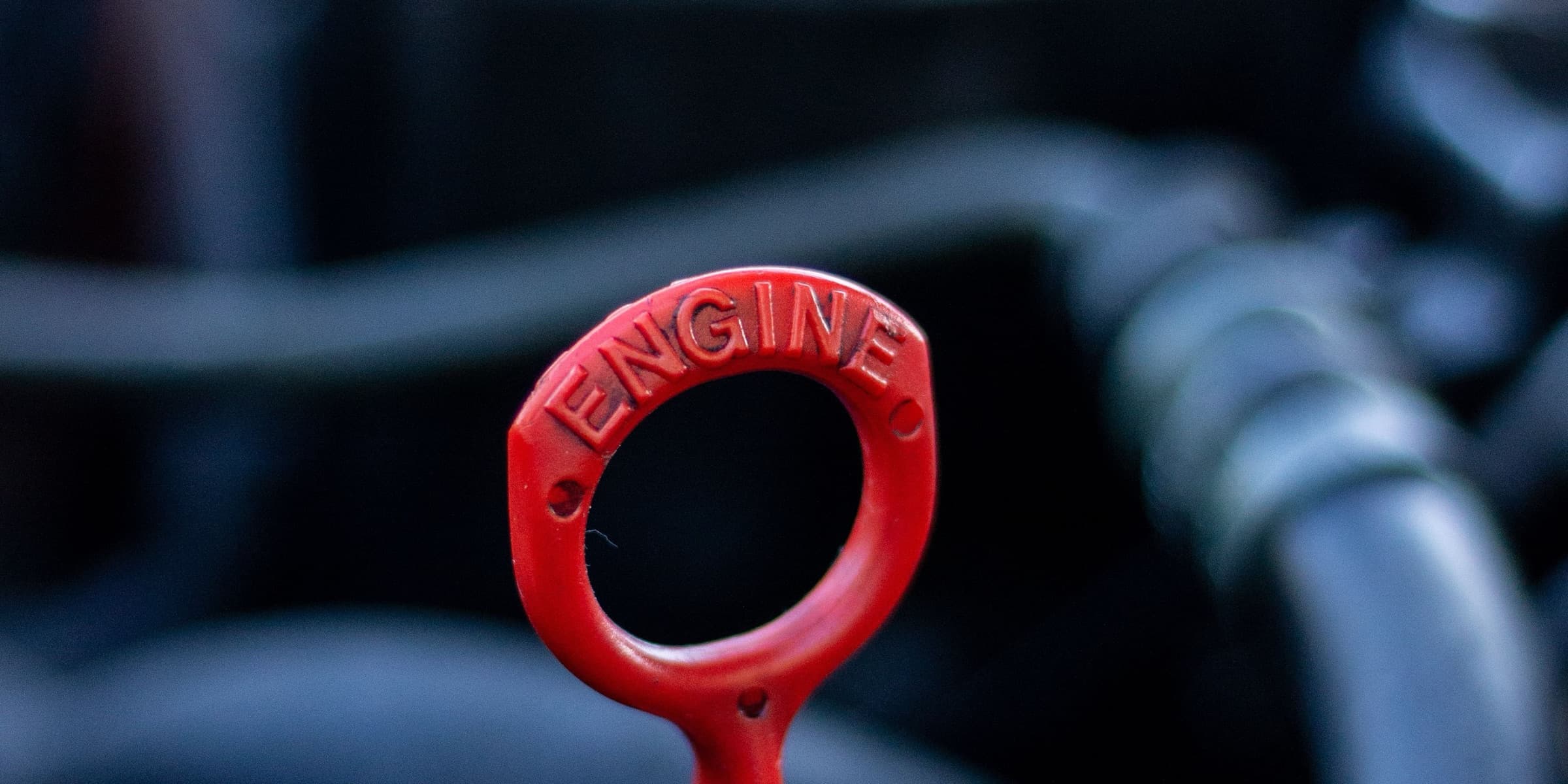 Red engine oil dipstick in a car engine